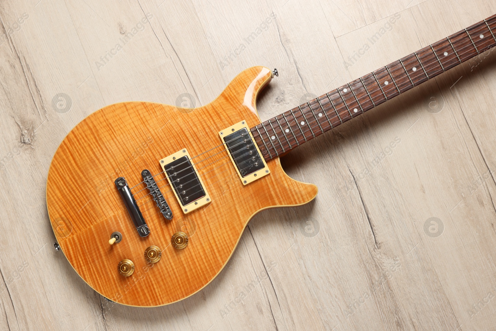 Photo of One modern electric guitar on wooden background, top view