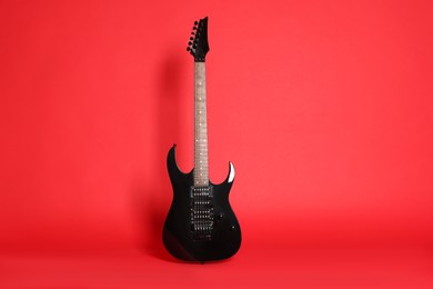 Photo of One modern electric guitar on red background