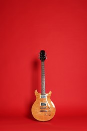 Photo of One modern electric guitar on red background