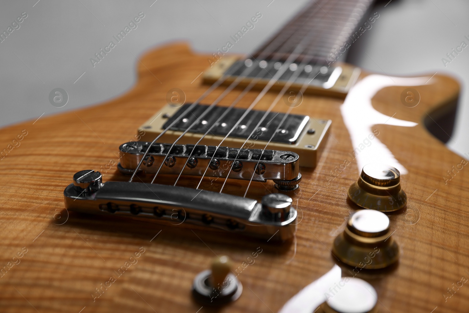 Photo of Modern electric guitar on grey background, closeup