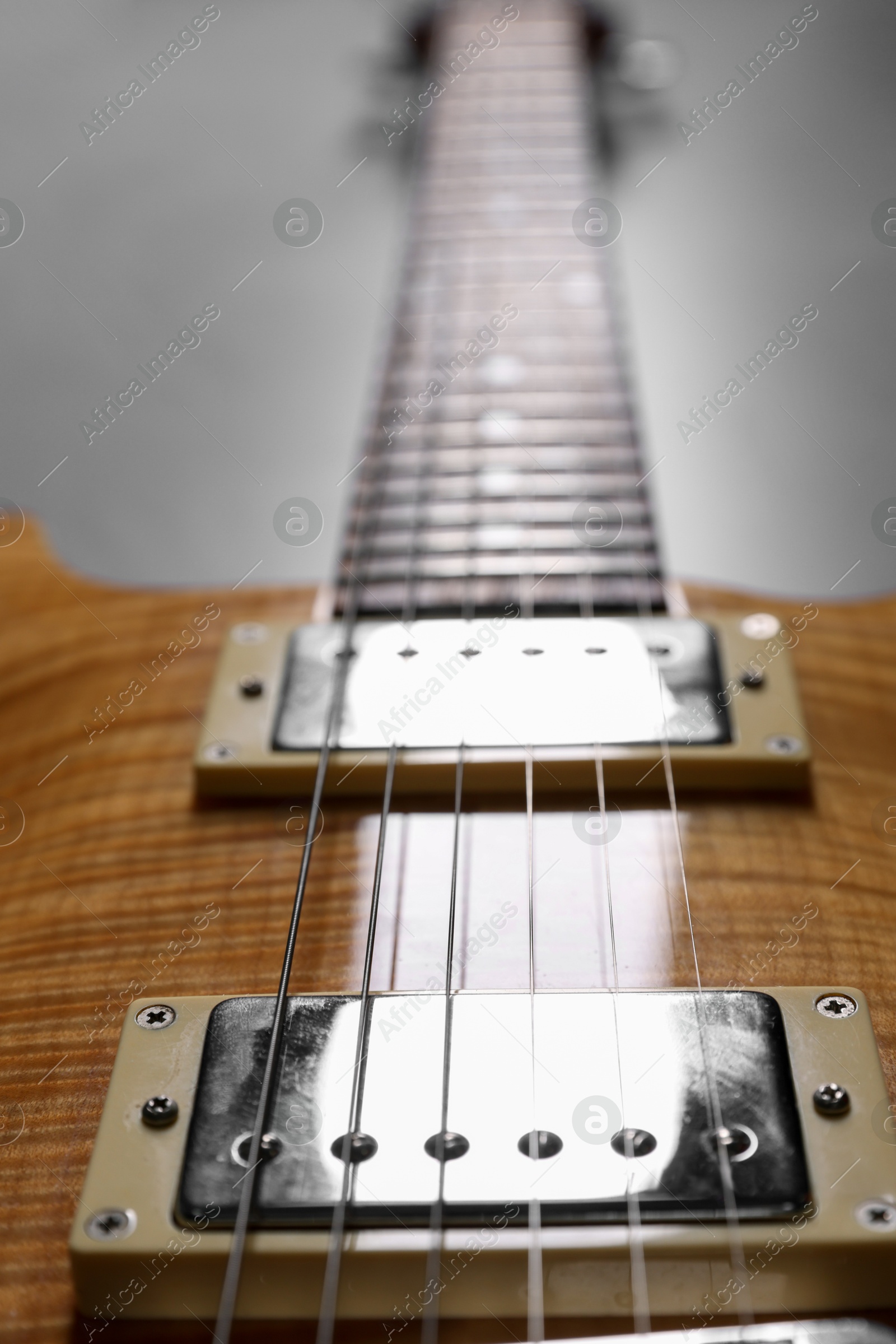 Photo of Modern electric guitar on grey background, closeup