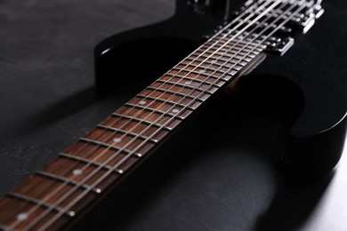 Photo of Modern electric guitar on black background, closeup