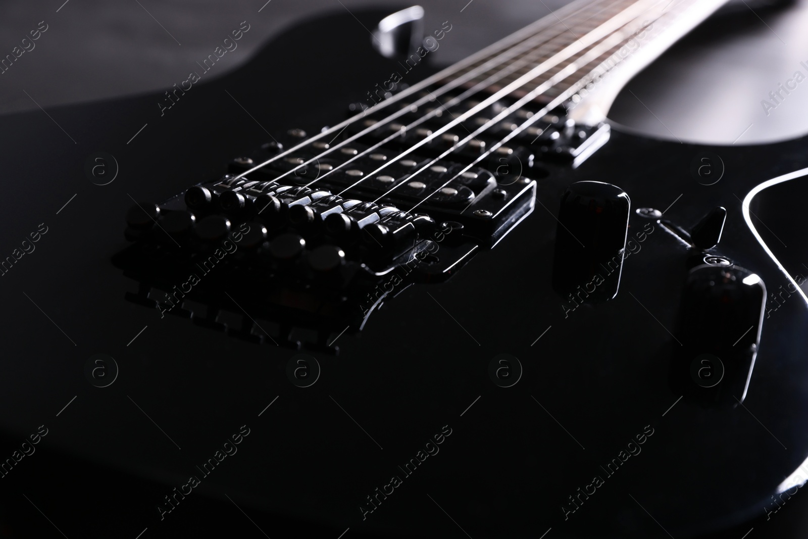 Photo of Modern electric guitar on black background, closeup