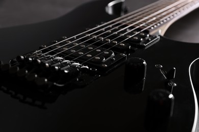 Photo of Modern electric guitar on black background, closeup