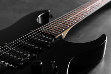 Photo of Modern electric guitar on black background, closeup