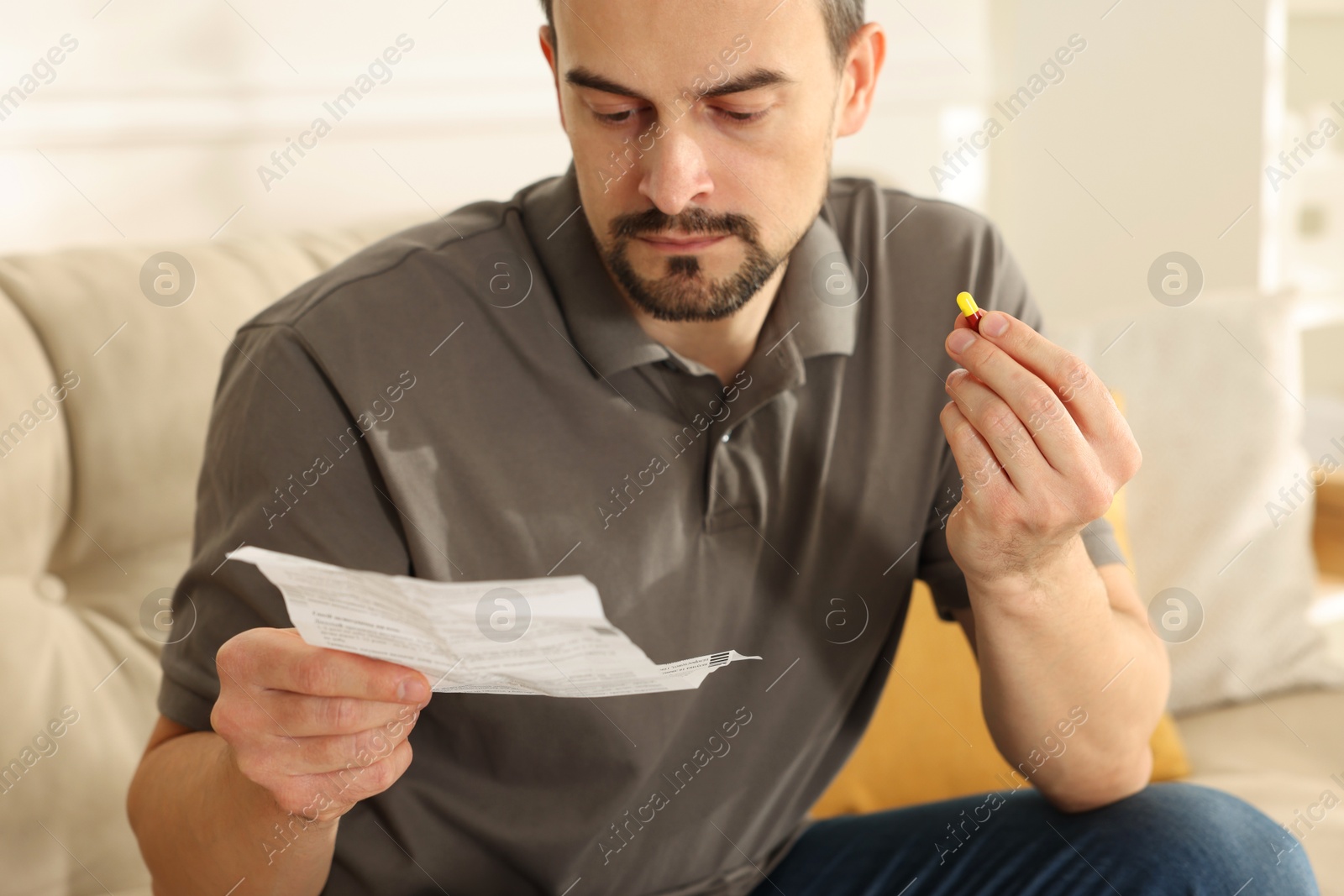 Photo of Man with pill reading instruction at home, closeup