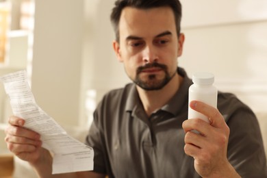 Photo of Man with pills and medical instruction at home, selective focus