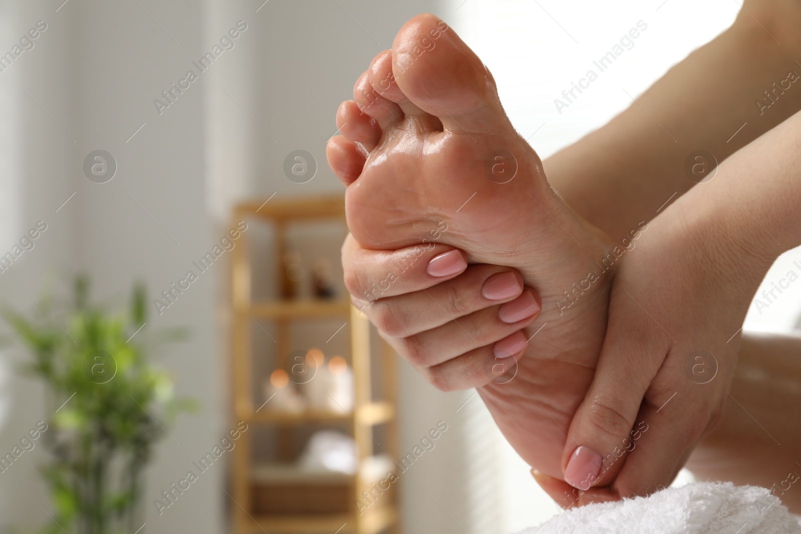Photo of Woman receiving foot massage in spa salon, closeup. Space for text
