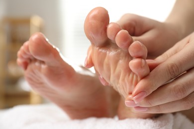 Photo of Woman receiving foot massage in spa salon, closeup