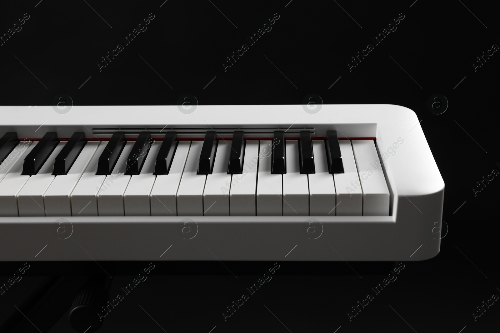 Photo of Synthesizer on black background, closeup. Electronic musical instrument