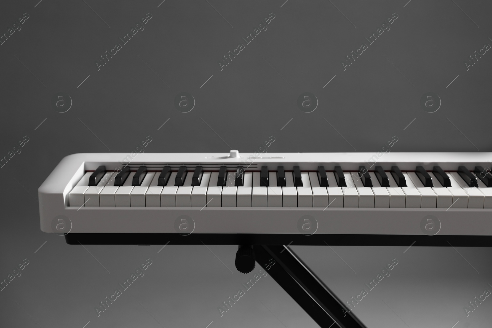 Photo of Synthesizer on grey background, closeup. Electronic musical instrument