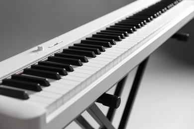 Photo of Synthesizer on grey background, closeup. Electronic musical instrument