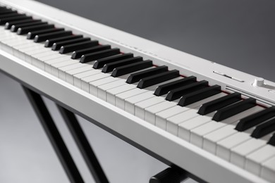 Photo of Synthesizer on grey background, closeup. Electronic musical instrument