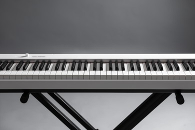 Photo of Synthesizer on grey background, closeup. Electronic musical instrument