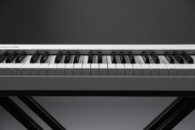 Photo of Synthesizer on grey background, closeup. Electronic musical instrument