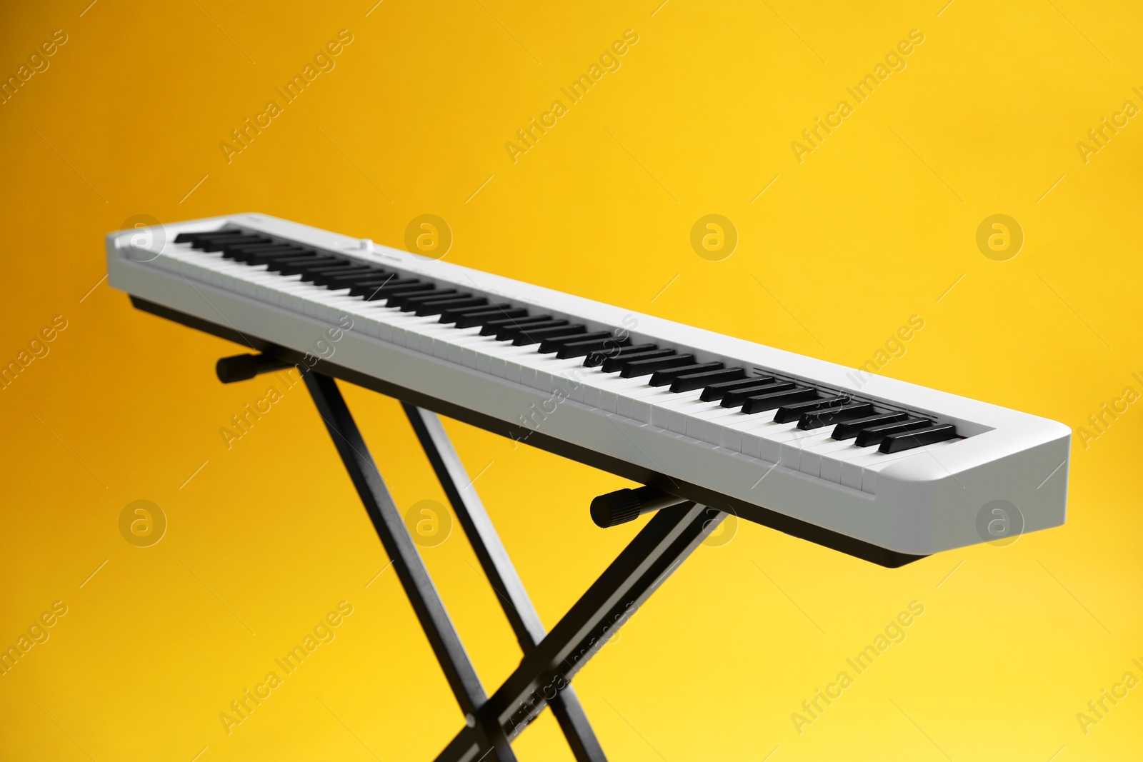 Photo of Synthesizer on yellow background, closeup. Electronic musical instrument