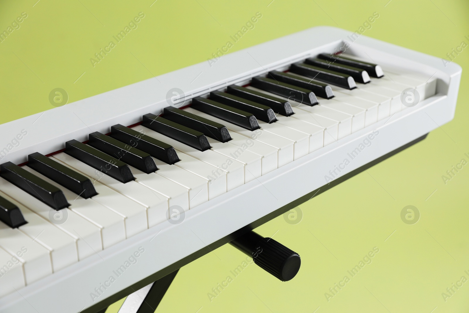 Photo of Synthesizer on green background, closeup. Electronic musical instrument