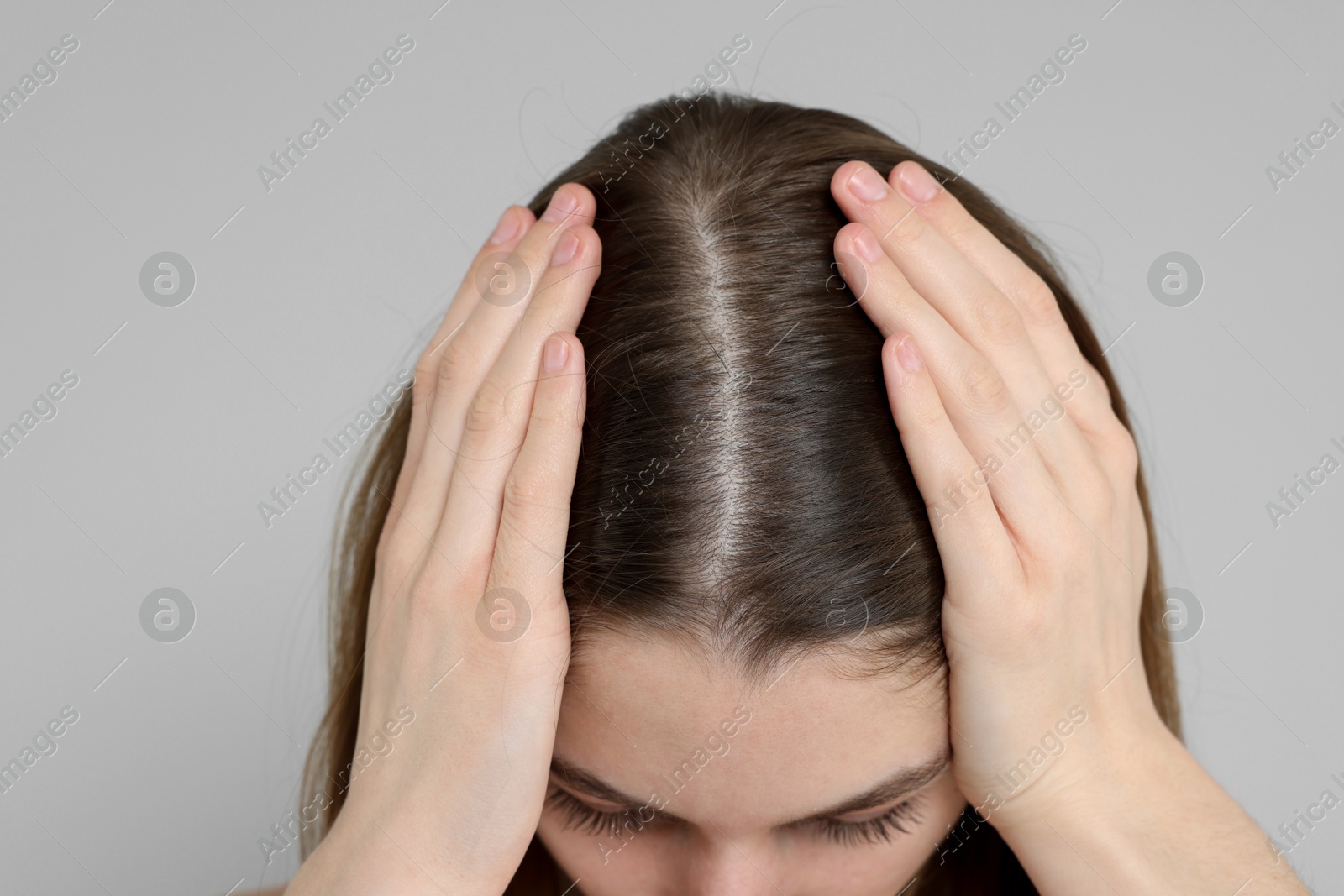 Photo of Girl with hair loss problem on grey background, closeup