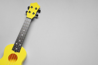 Photo of One ukulele on grey background, top view. Space for text