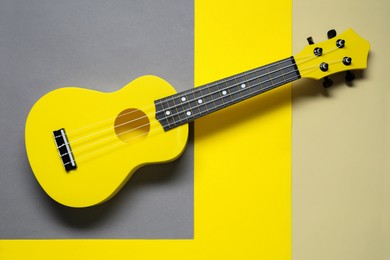 Photo of One ukulele on color background, top view