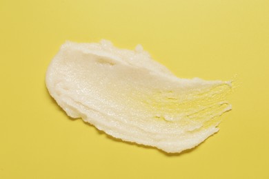 Photo of Sample of body scrub on yellow background, top view