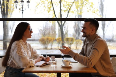 Photo of Man and woman working together in cafe