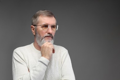 Photo of Portrait of mature man in glasses on grey background, space for text