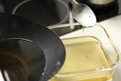 Photo of Pouring used cooking oil at white countertop, closeup