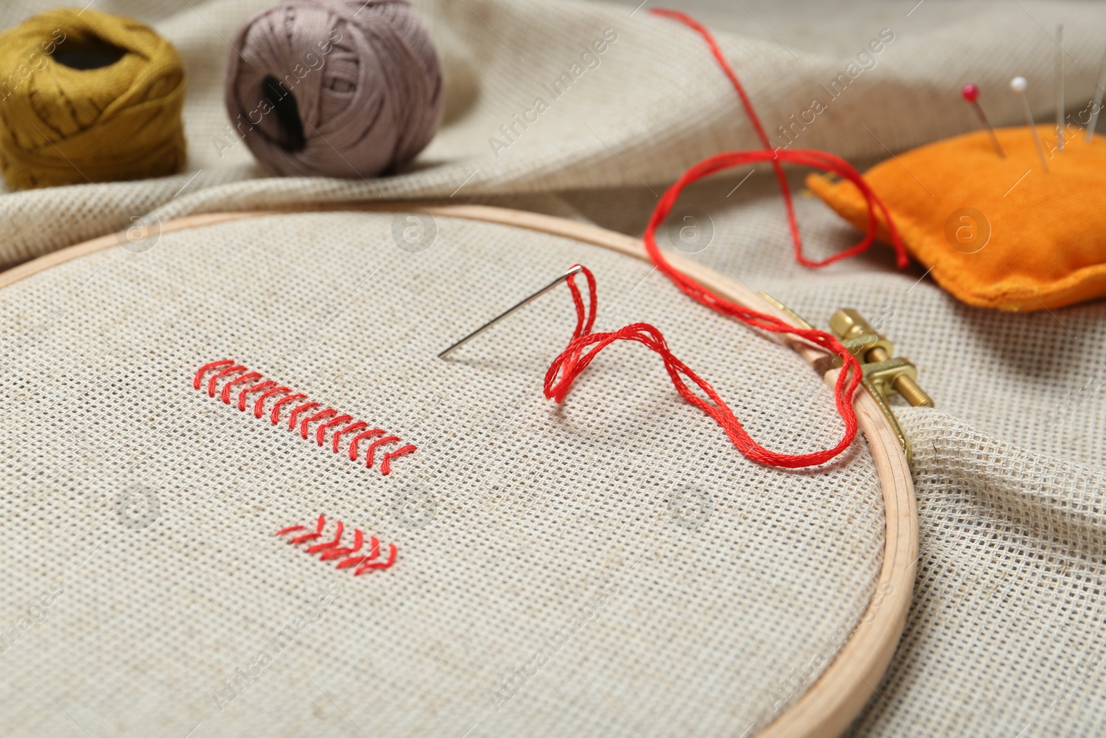 Photo of Embroidery and different sewing accessories on table, closeup