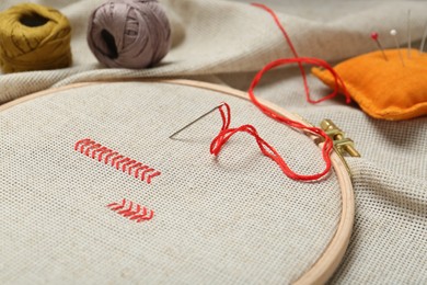 Embroidery and different sewing accessories on table, closeup