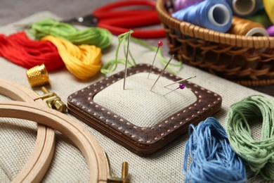 Photo of Embroidery. Different sewing accessories on table, closeup