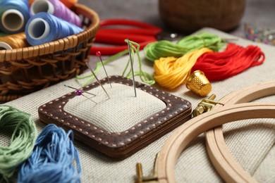 Photo of Embroidery. Different sewing accessories on table, closeup