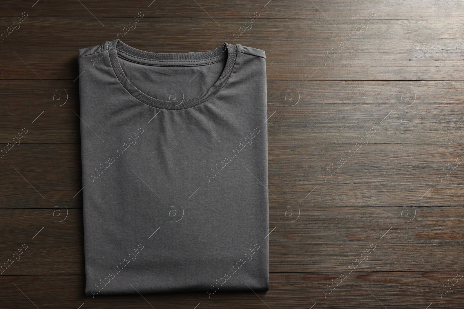 Photo of Blank grey t-shirt on wooden background, top view. Mockup for design