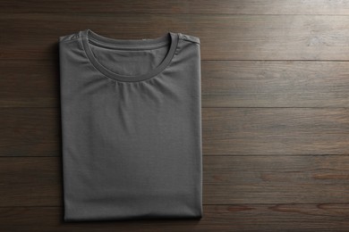 Photo of Blank grey t-shirt on wooden background, top view. Mockup for design