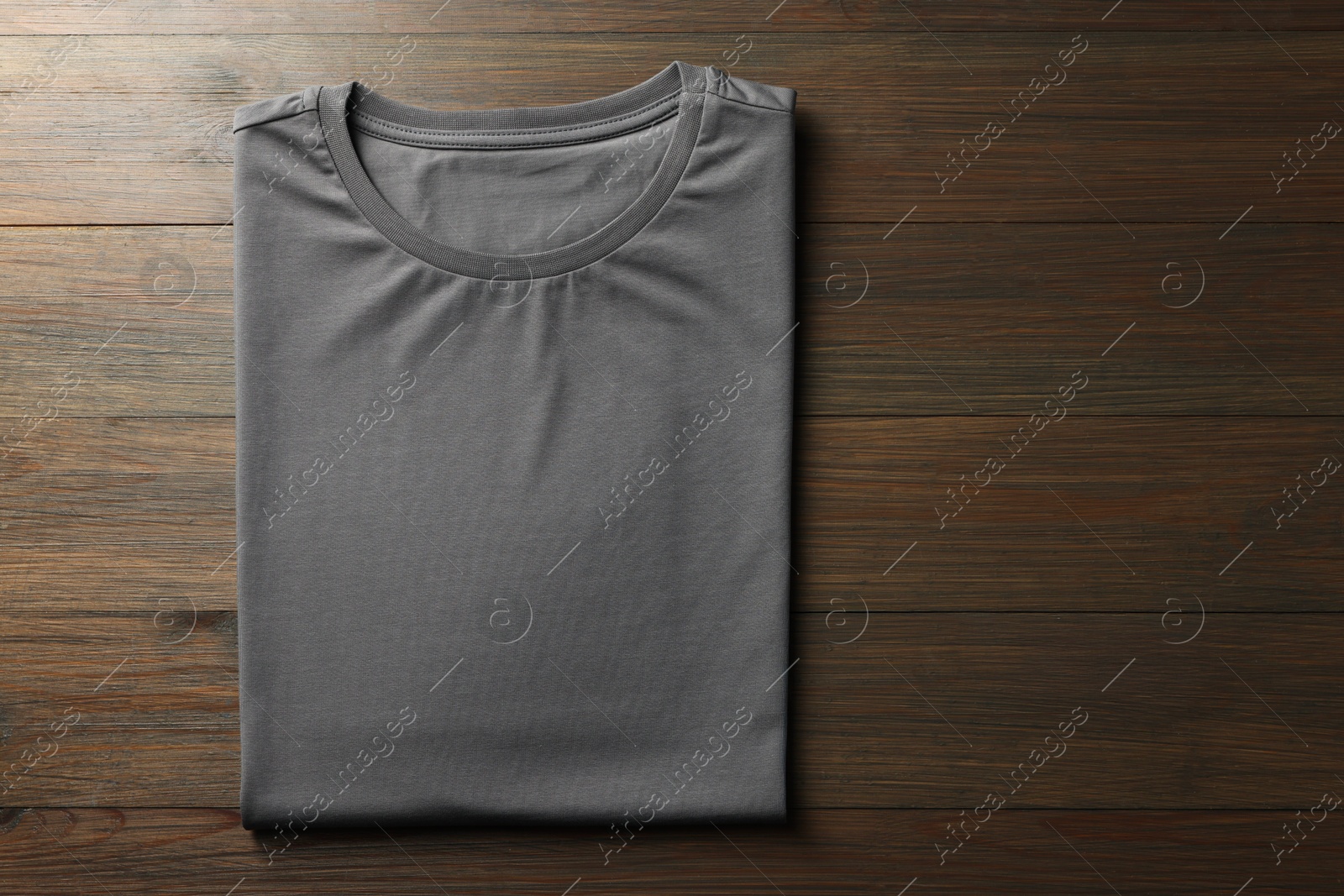 Photo of Blank grey t-shirt on wooden background, top view. Mockup for design