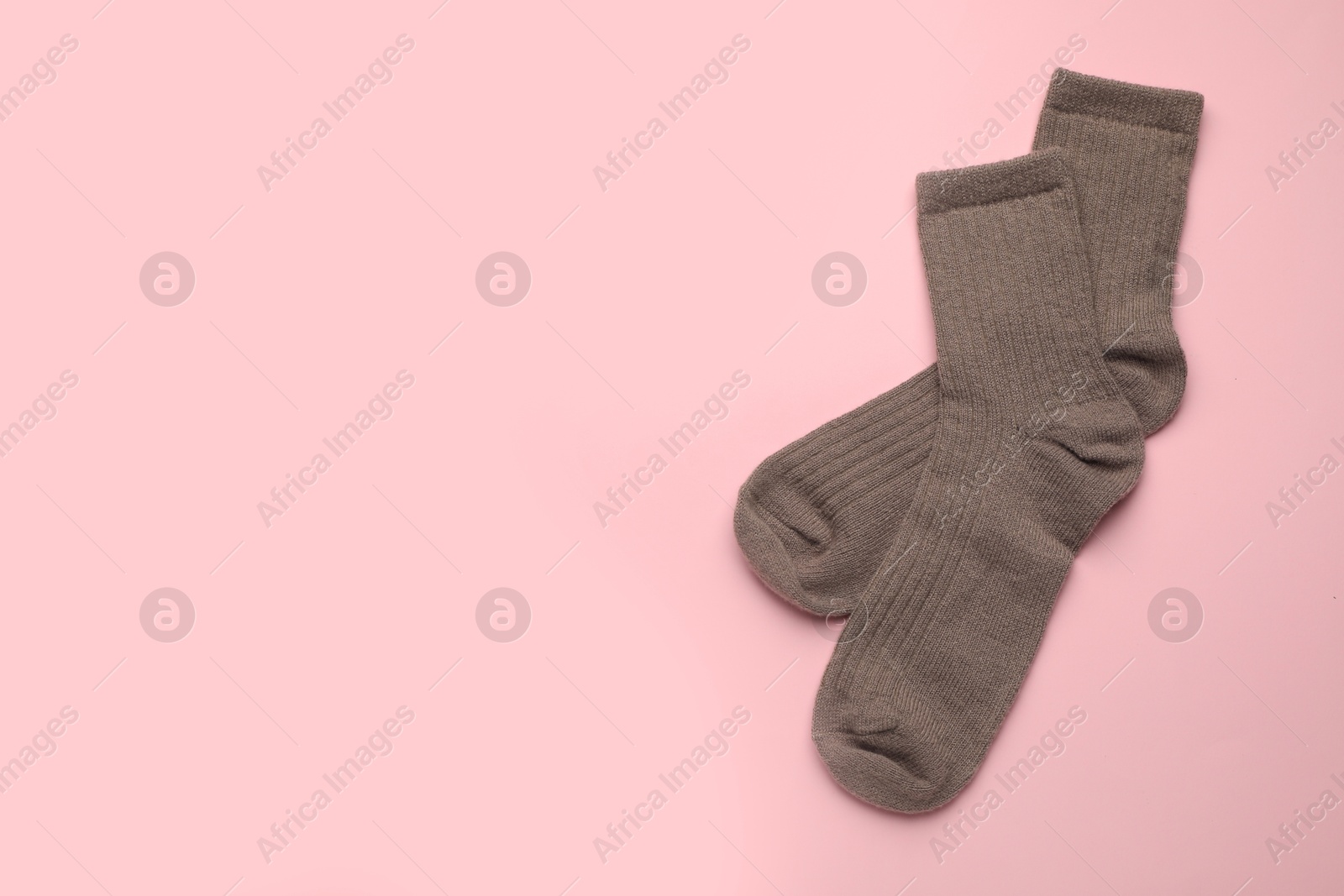 Photo of Pair of soft socks on pink background, top view. Space for text