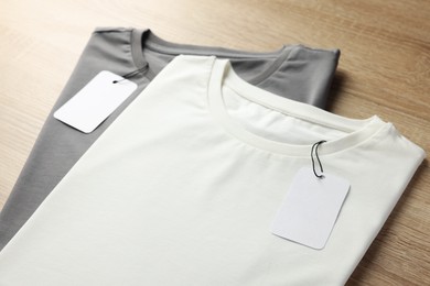 Blank t-shirts on wooden background, closeup. Mockup for design