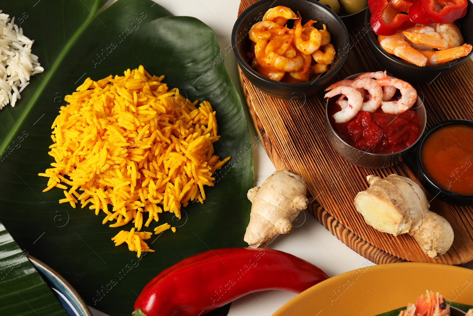 Photo of Cut banana leaf with different food on white table, above view