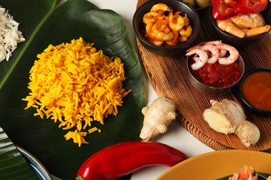 Cut banana leaf with different food on white table, above view