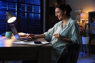 Photo of Woman working on laptop at desk in home office