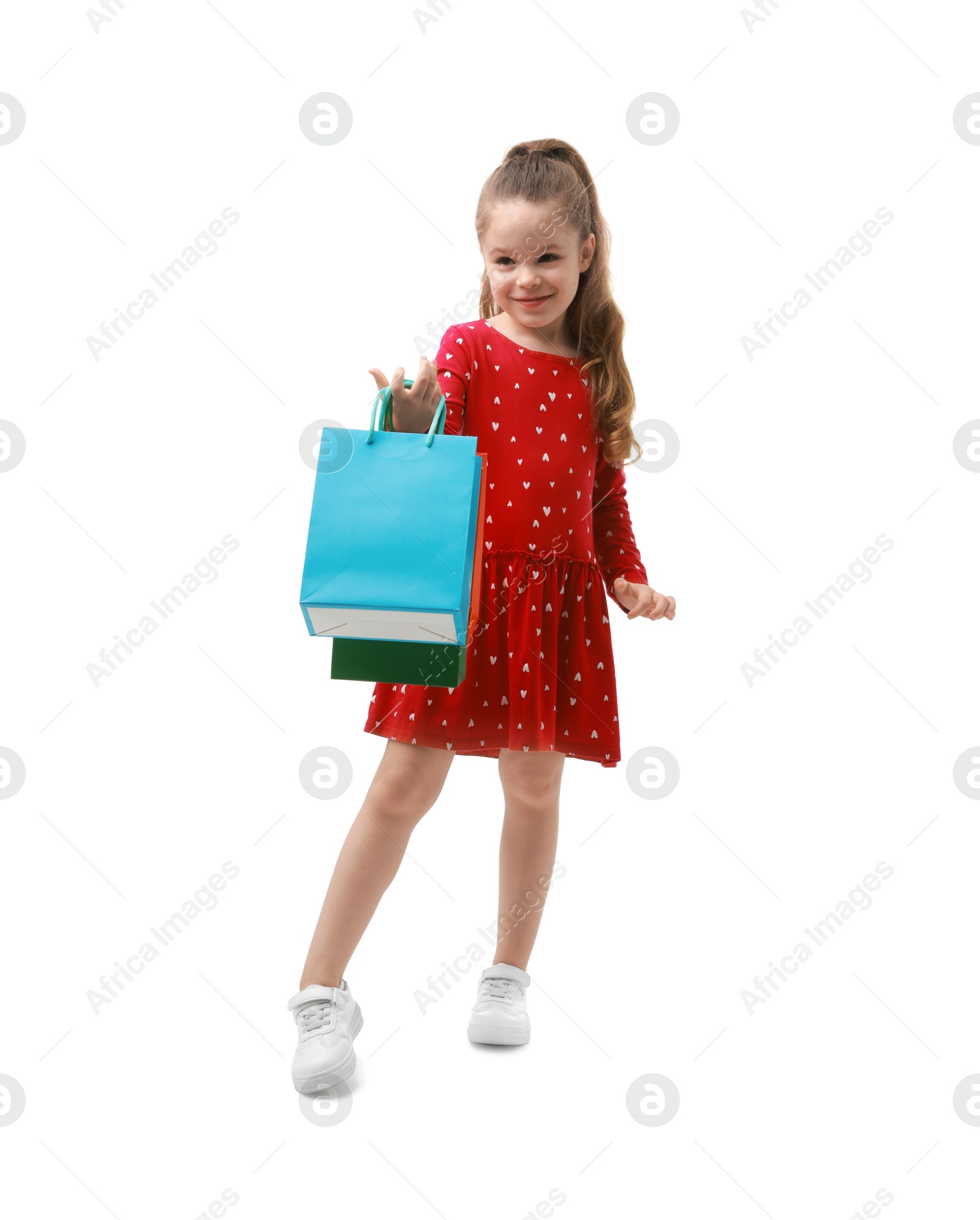 Photo of Cute little girl with shopping bags on white background