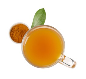 Photo of Aromatic turmeric tea in glass cup, powder and green leaf isolated on white, top view