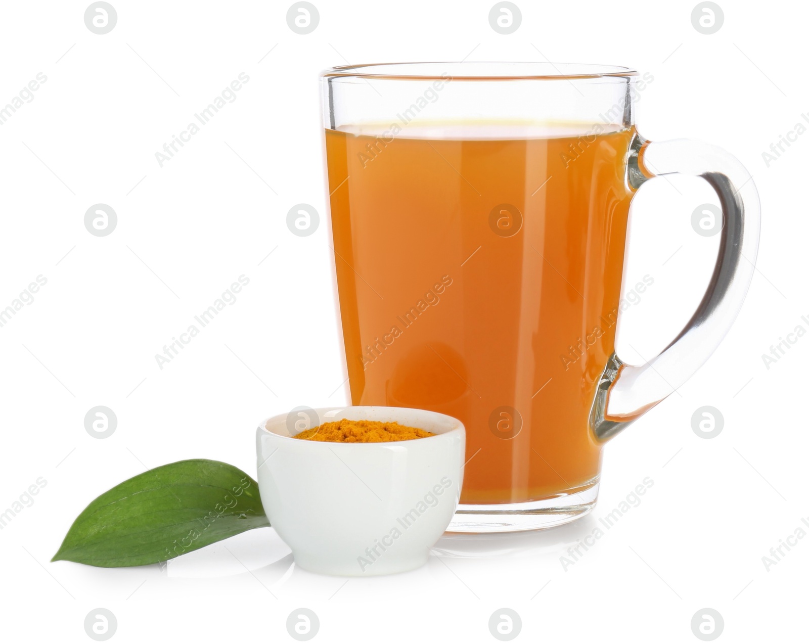 Photo of Aromatic turmeric tea in glass cup, powder and green leaf isolated on white