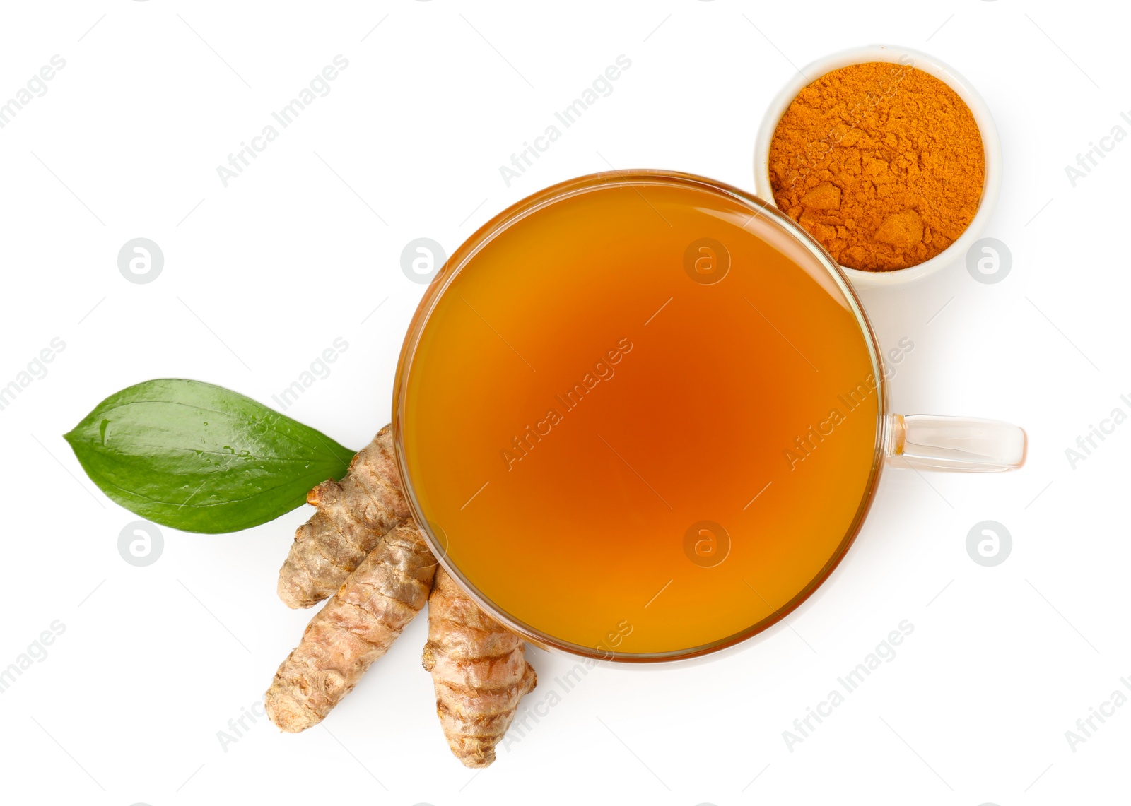 Photo of Aromatic turmeric tea in glass cup, roots, powder and green leaf isolated on white, top view