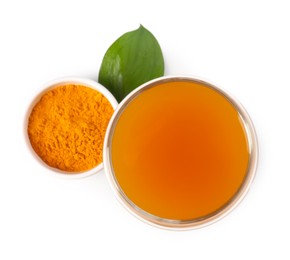 Photo of Aromatic turmeric tea in glass, green leaf and powder isolated on white, top view