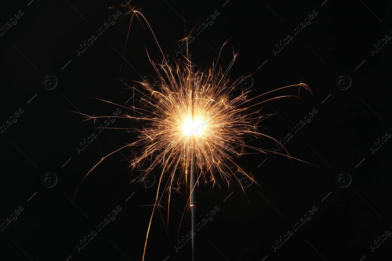 Photo of Bright burning sparkler on black background, closeup