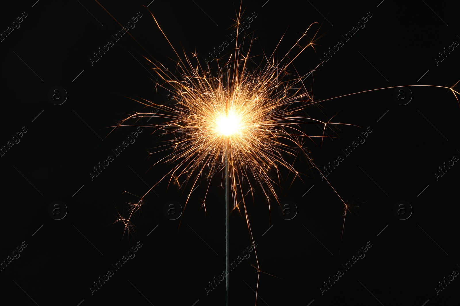 Photo of Bright burning sparkler on black background, closeup