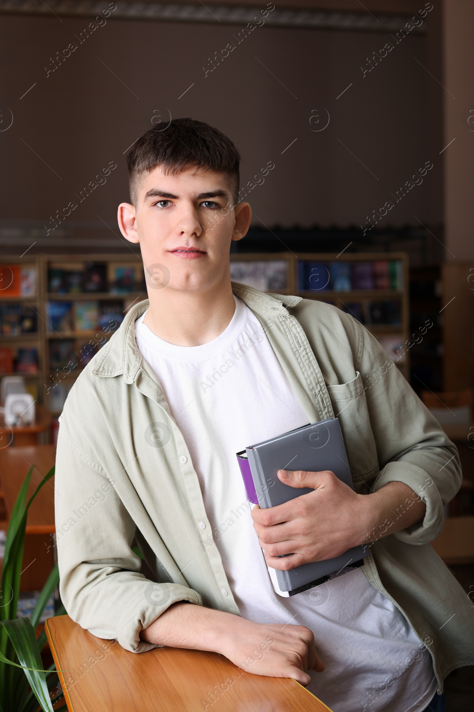 Photo of Portrait of handsome man with books in library