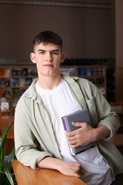 Photo of Portrait of handsome man with books in library