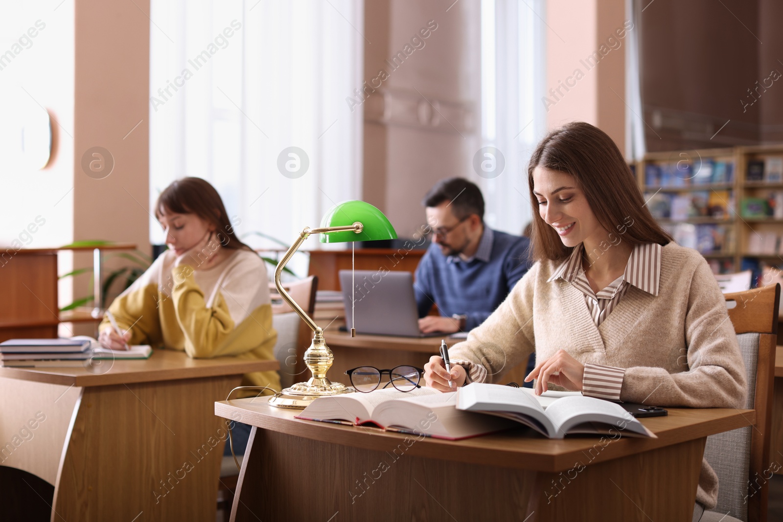 Photo of Group of people working at desks in public library